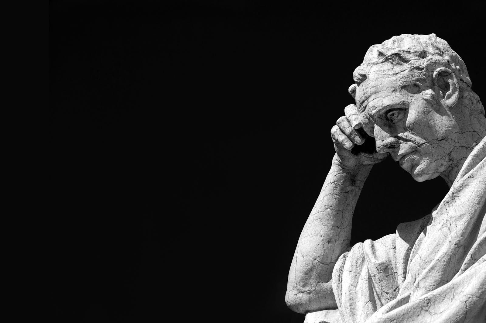 stone sculpture of a man thinking