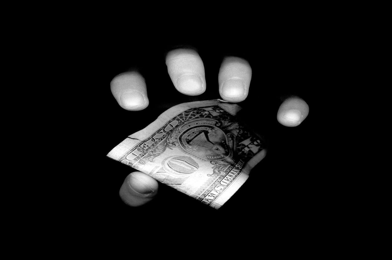 Fingers holding dollar bill