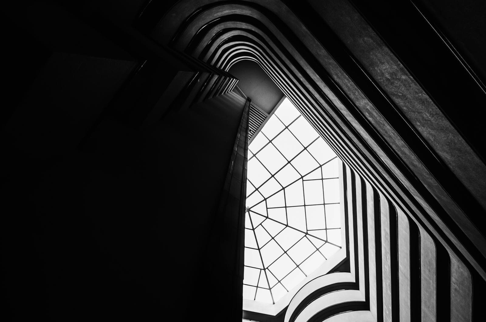 looking up to a panelled glass roof in building interior