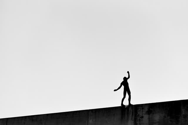 person balancing on edge of a gate