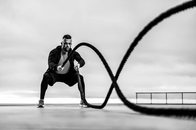 man doing battle rope swings