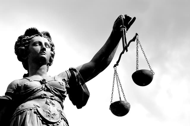 Stone statue holding up the scales of justice