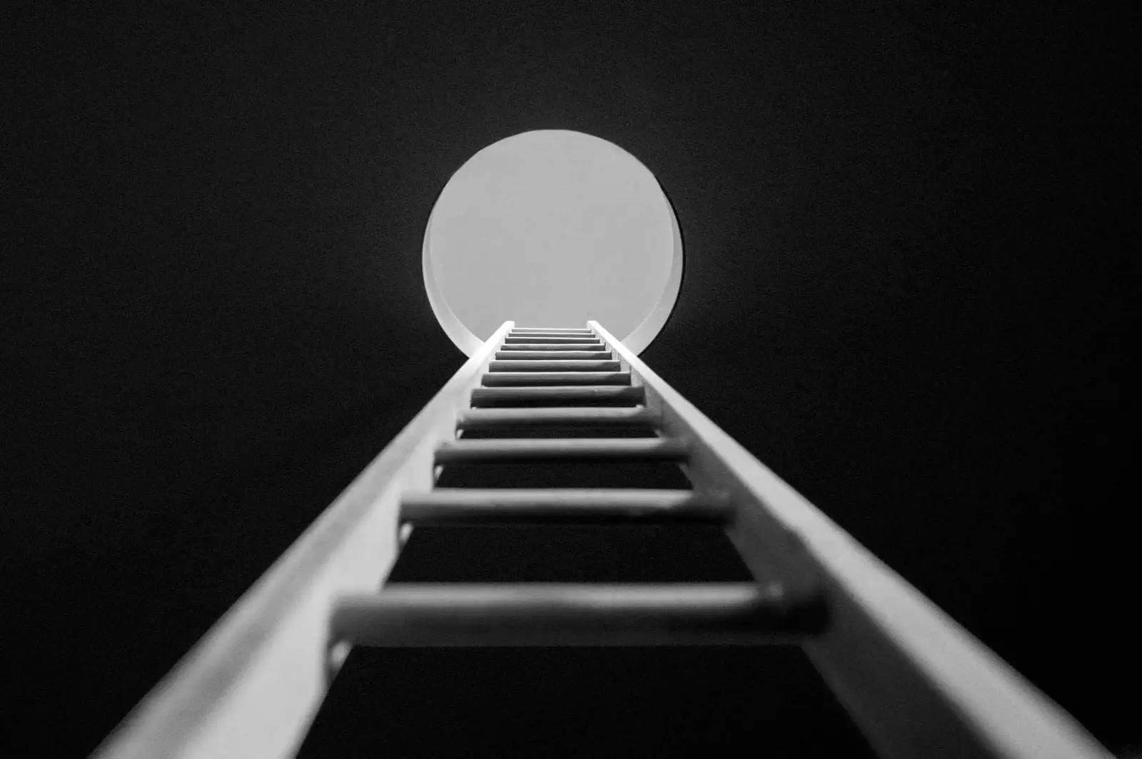 View from a ladder down a well looking up towards daylight