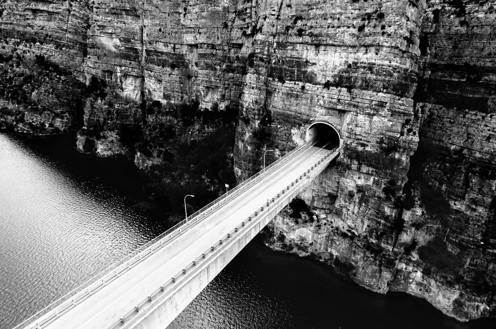 Bridge over river going into mountain side tunnel