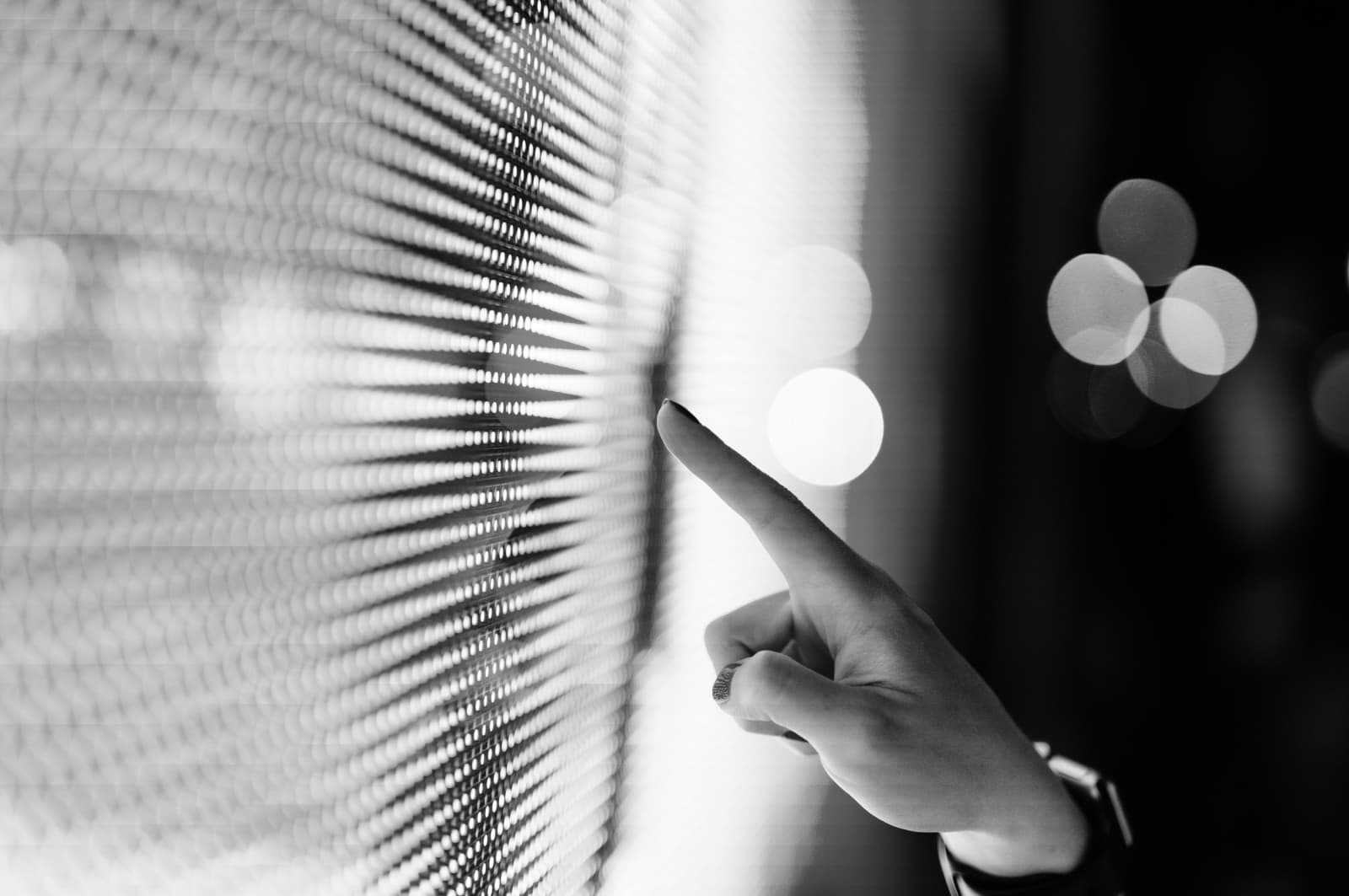 Close up of hand touching illuminated digital display in the dark