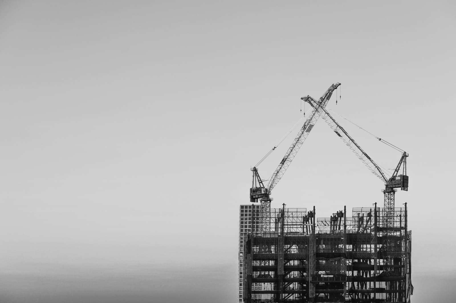 Two cranes building scaffolding