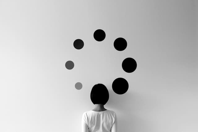 A woman looking at dots gradually fading on the wall