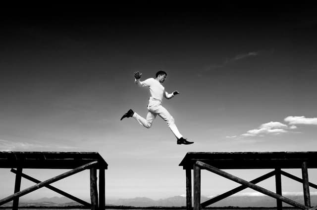 a person leaping from one wooden ledge to another